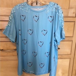 Pale blue, short sleeve blouse w/ hearts & lace. Size 2 XL. Polyester & cotton.